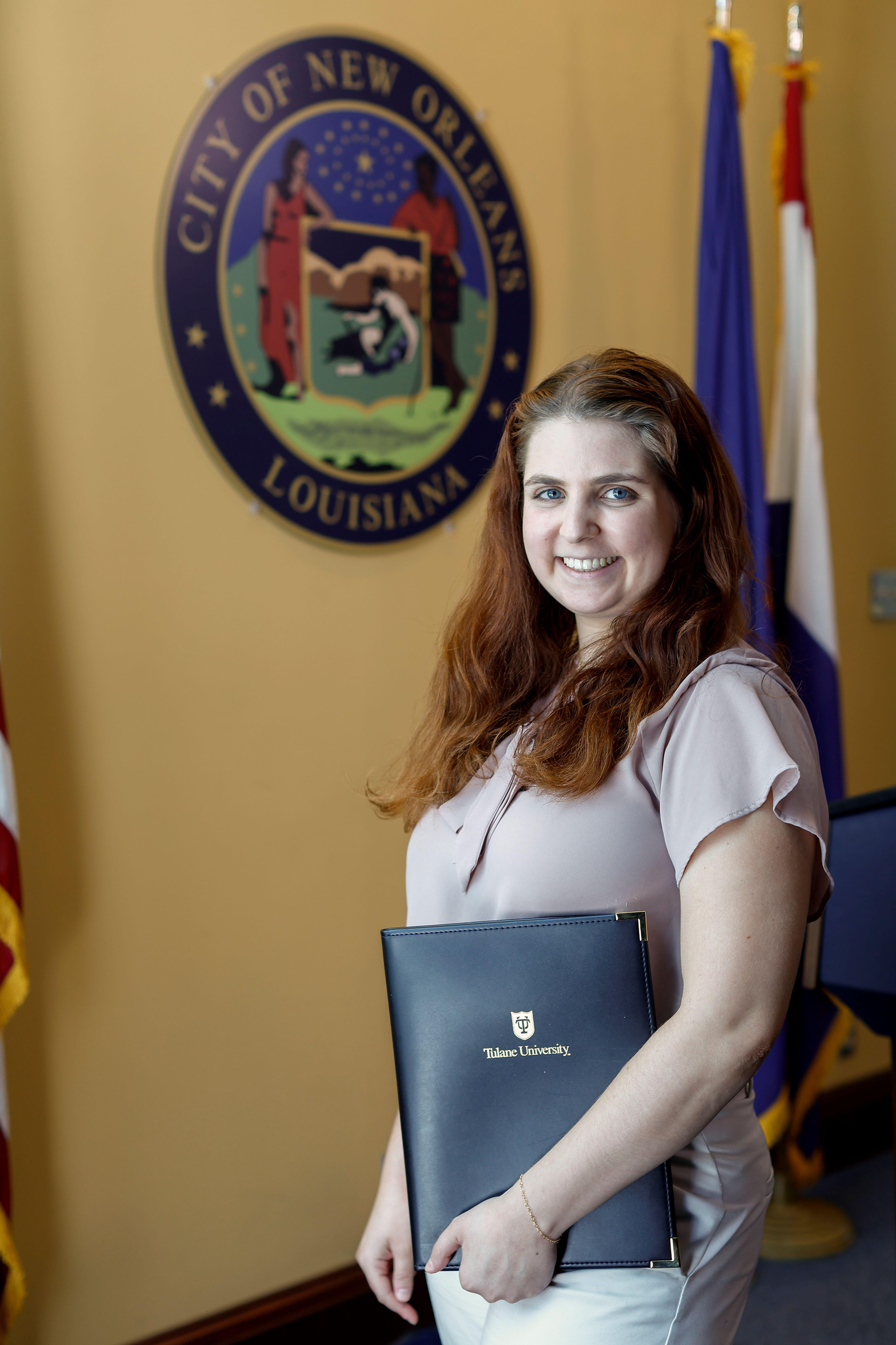 Giulia Silver smiles in front of the New Orleans crest.