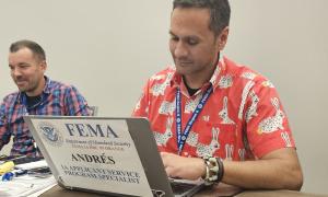 Andy Melendez Salgado types at his FEMA computer.