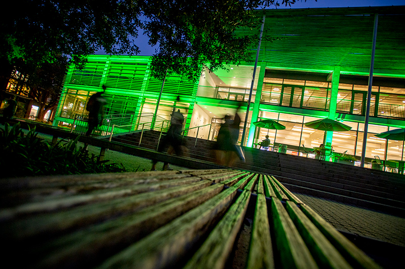 Student center on Tulane's Uptown Campus is lighted with green for Homecoming celebrations.